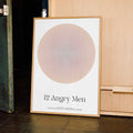 Framed poster titled '12 Angry Men' leaning against a wooden cabinet.