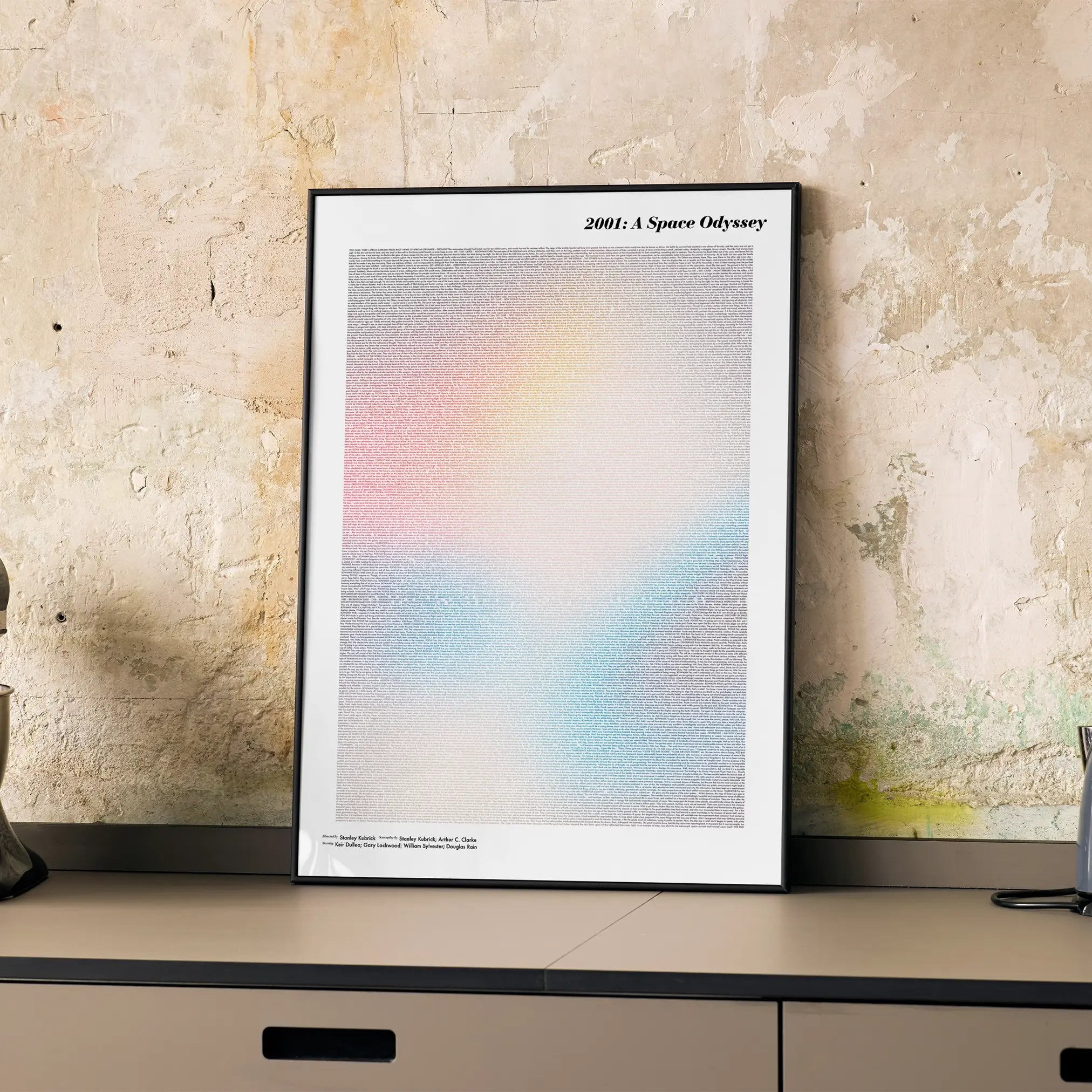 A framed 2001: A Space Odyssey movie script poster displayed on a cabinet in a minimalist interior.