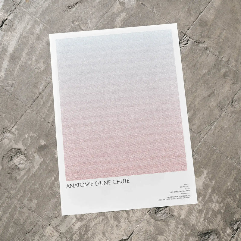 A Anatomie d'une chute movie script poster laid flat on a textured floor surface.