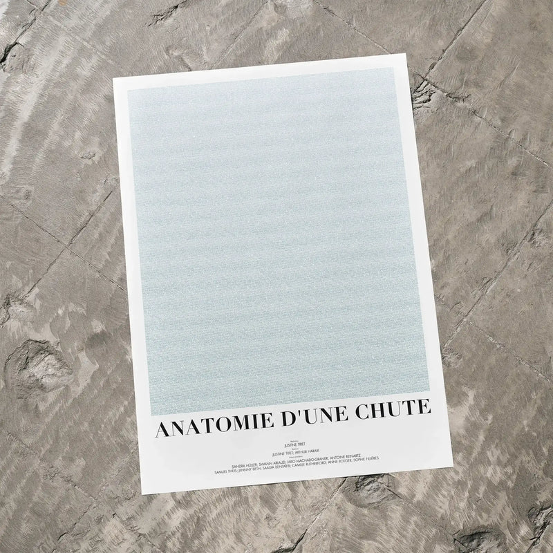 A Anatomie d'une chute movie script poster laid flat on a textured floor surface.