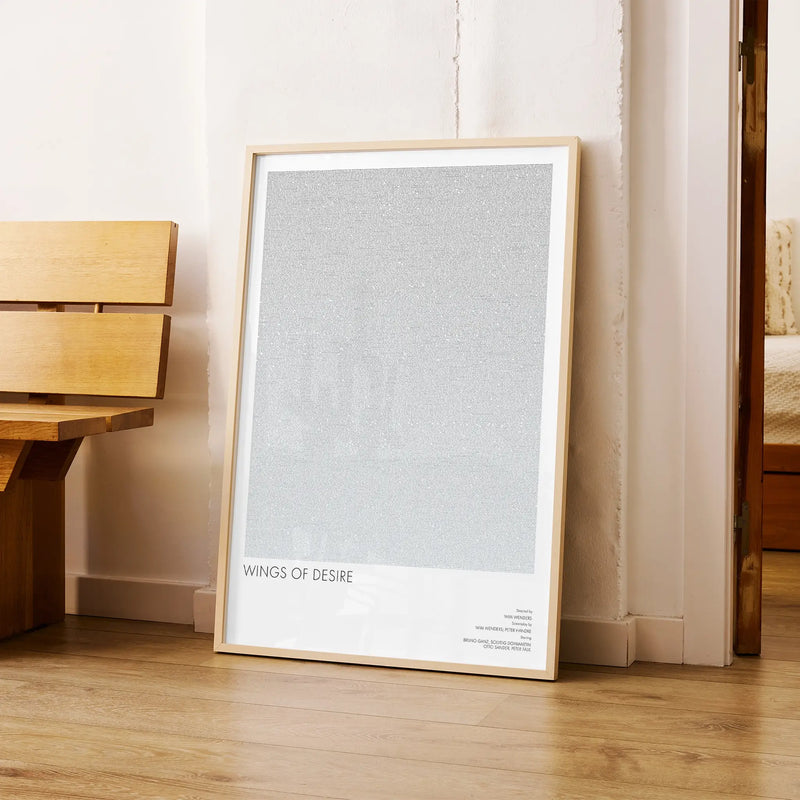 A framed Wings of Desire movie script poster arranged in a minimalist interior setting.