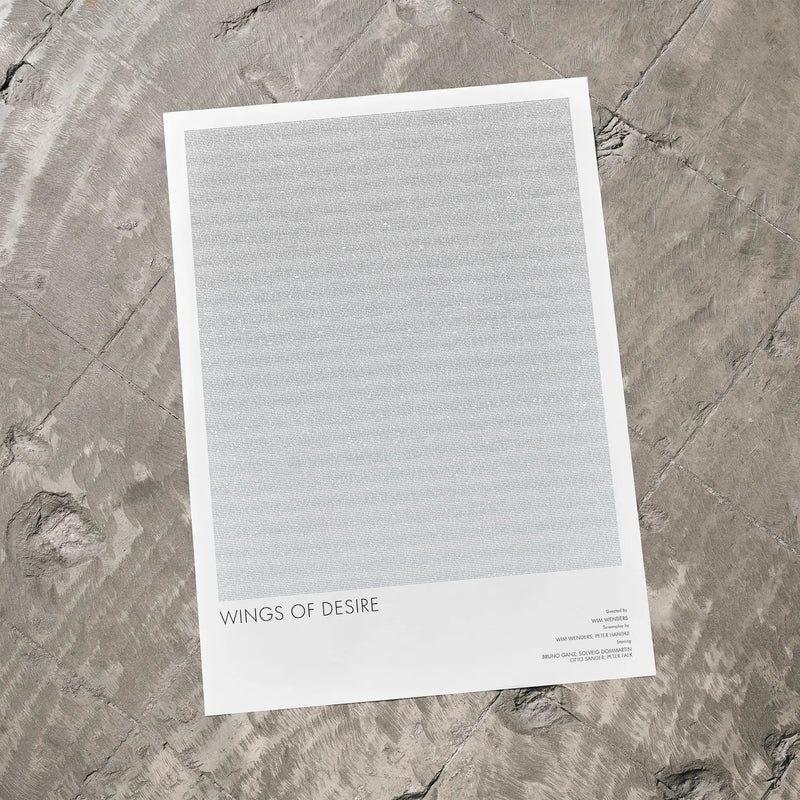 A Wings of Desire movie script poster laid flat on a textured floor surface.