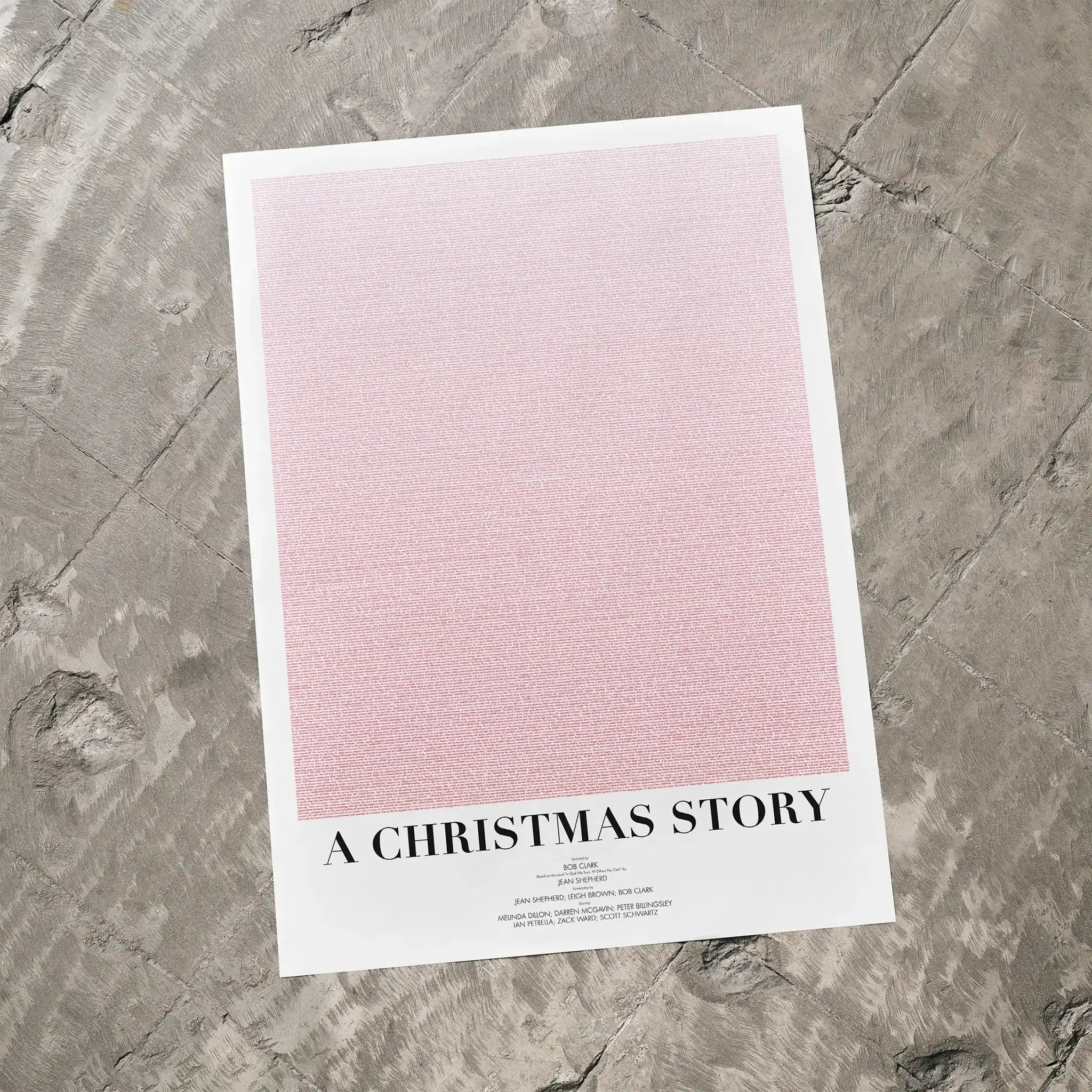 A A Christmas Story movie script poster laid flat on a textured floor surface.