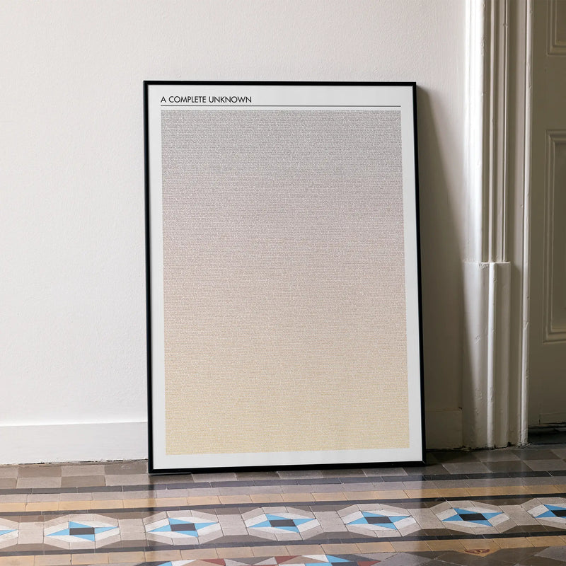 A framed A Complete Unknown movie script poster leaning against a wall in a minimalist interior.