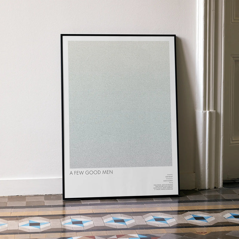 A framed A Few Good Men movie script poster leaning against a wall in a minimalist interior.