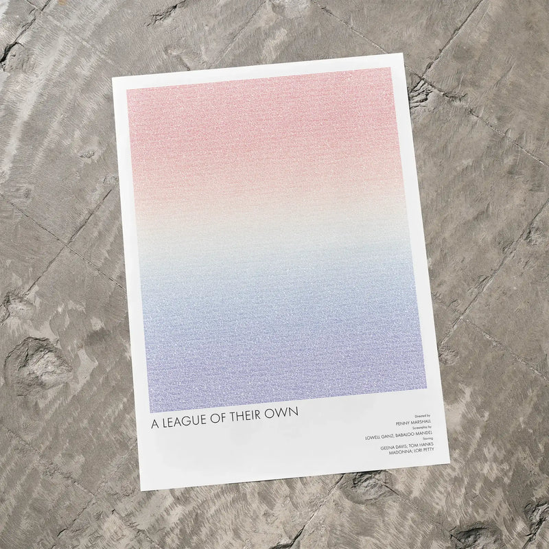 A A League of Their Own movie script poster laid flat on a textured floor surface.