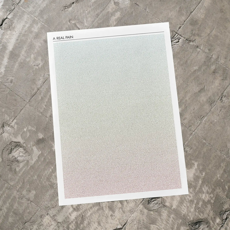 A A Real Pain movie script poster laid flat on a textured floor surface.