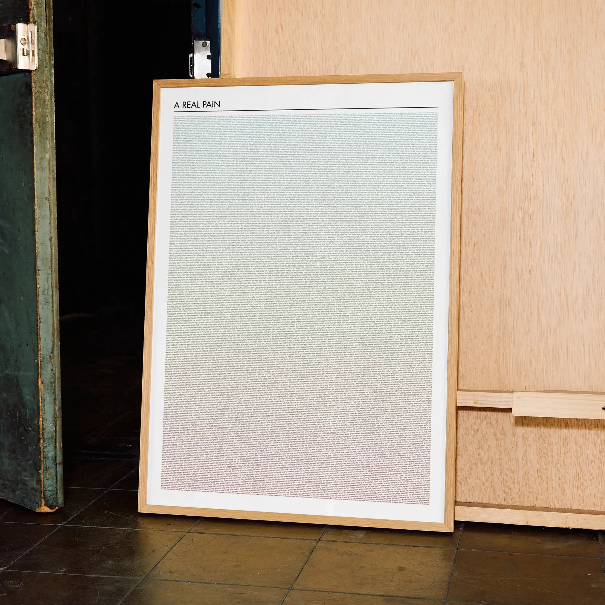 A framed A Real Pain movie script poster displayed in a contemporary interior setting.