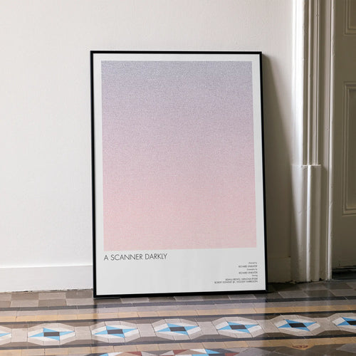 A framed A Scanner Darkly movie script poster leaning against a wall in a minimalist interior.