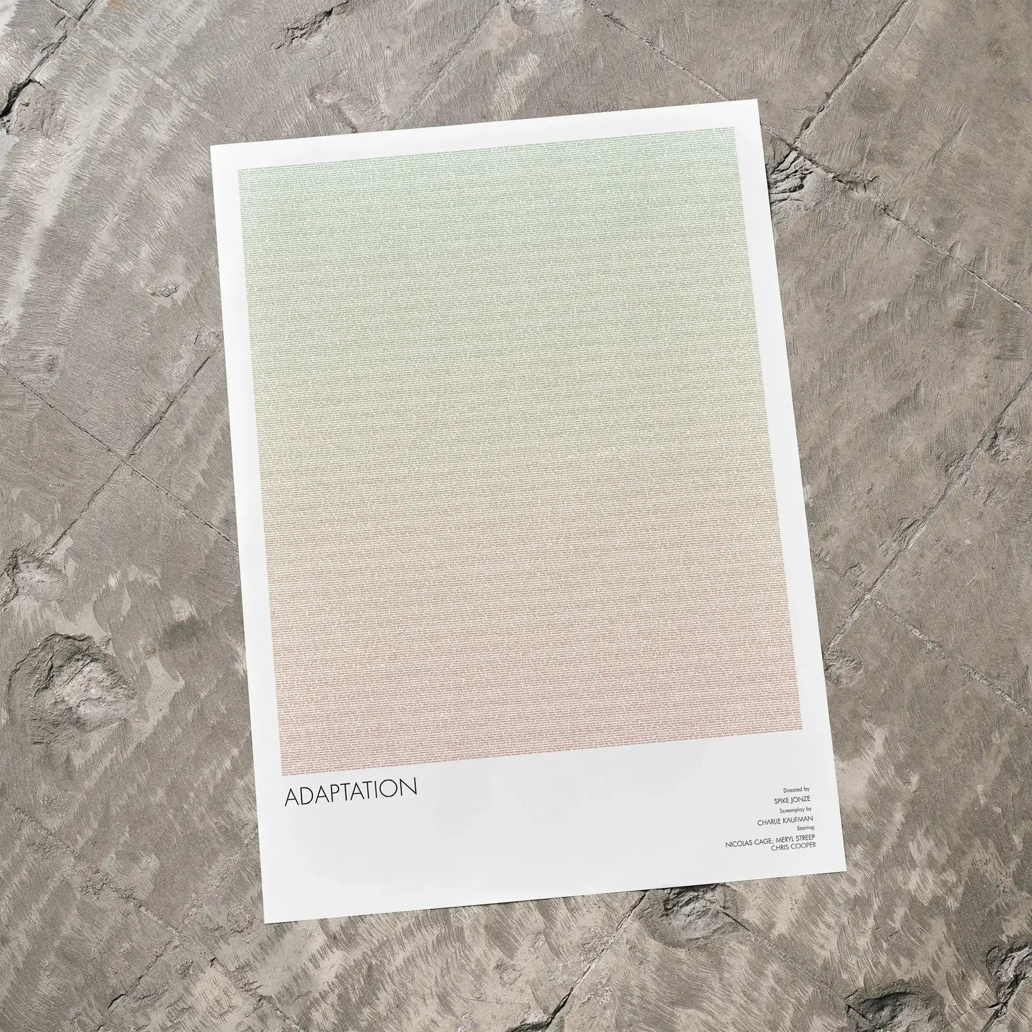 A Adaptation movie script poster laid flat on a textured floor surface.