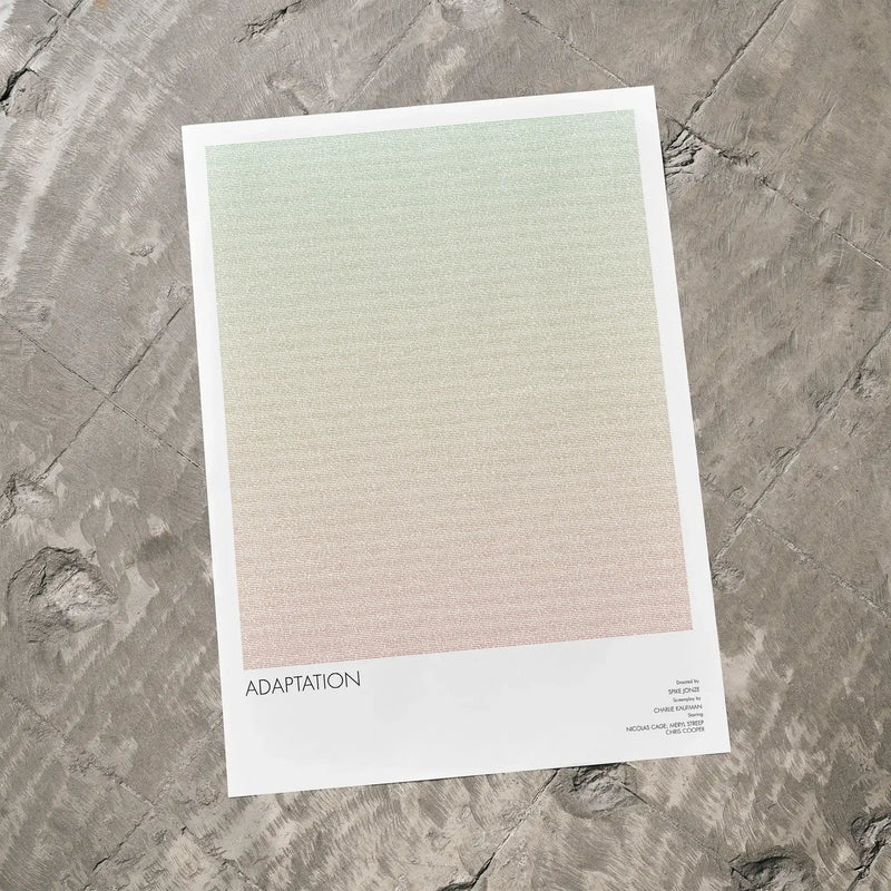 A Adaptation movie script poster laid flat on a textured floor surface.