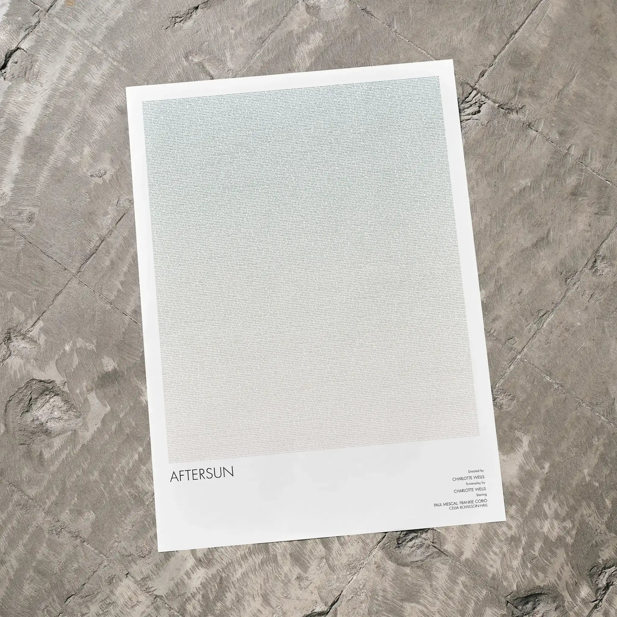 A Aftersun movie script poster laid flat on a textured floor surface.