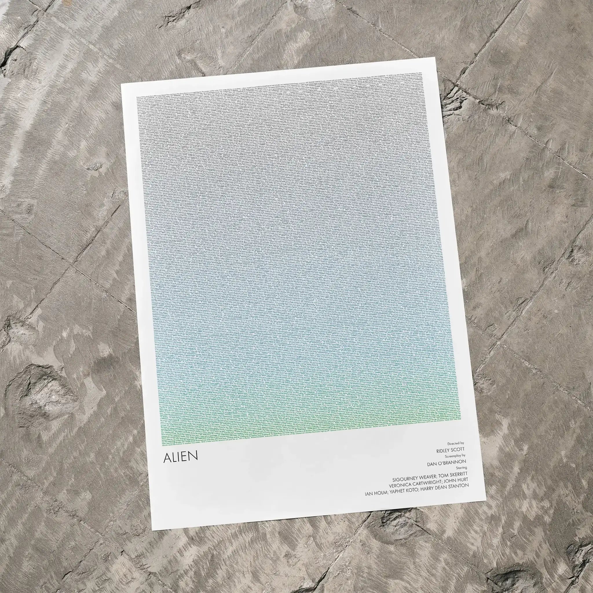 A Alien movie script poster laid flat on a textured floor surface.