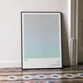 A framed Alien movie script poster leaning against a wall in a minimalist interior.