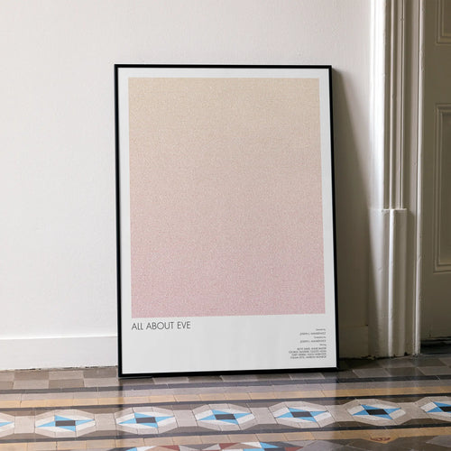 A framed All About Eve movie script poster leaning against a wall in a minimalist interior.