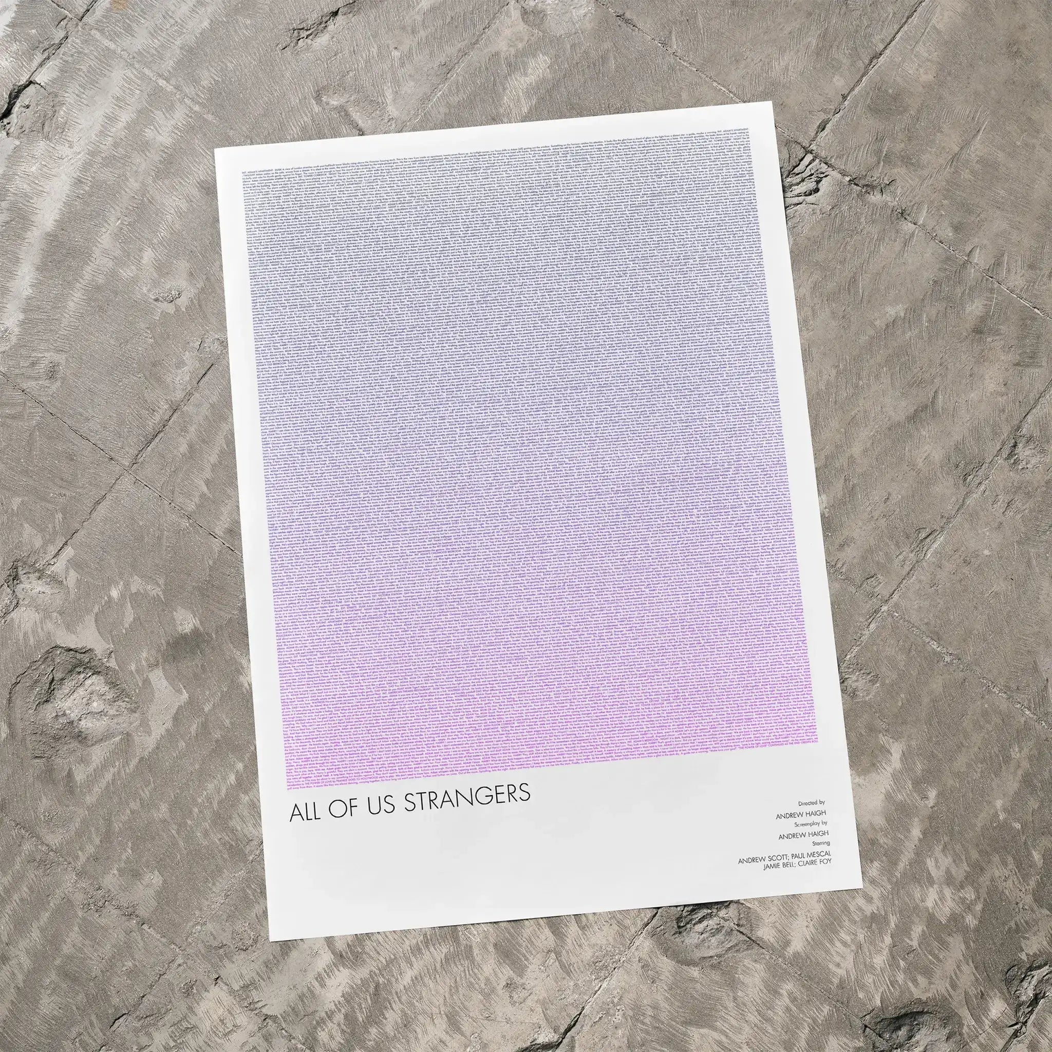 A All of Us Strangers movie script poster laid flat on a textured floor surface.