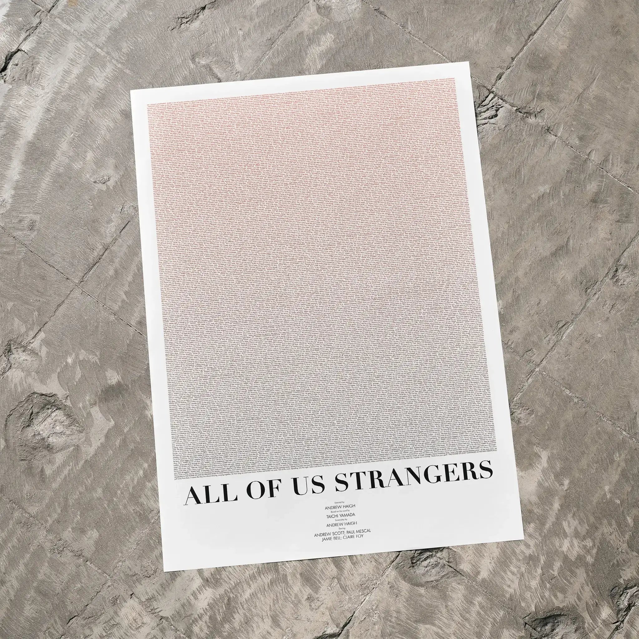 A All of Us Strangers movie script poster laid flat on a textured floor surface.