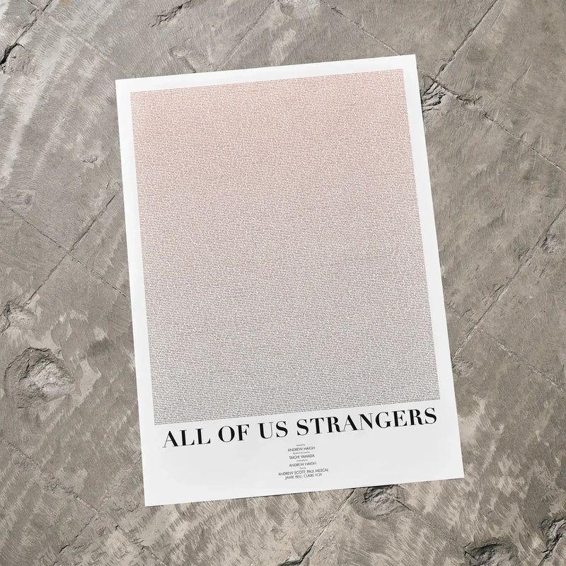 A All of Us Strangers movie script poster laid flat on a textured floor surface.