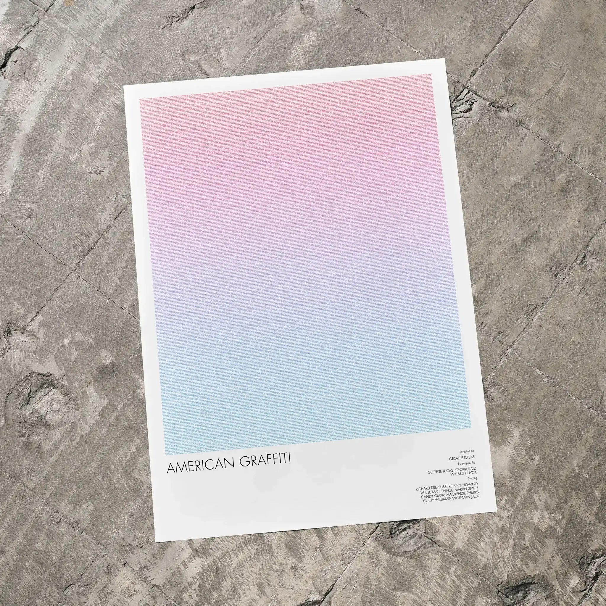 A American Graffiti movie script poster laid flat on a textured floor surface.