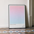 A framed American Graffiti movie script poster leaning against a wall in a minimalist interior.