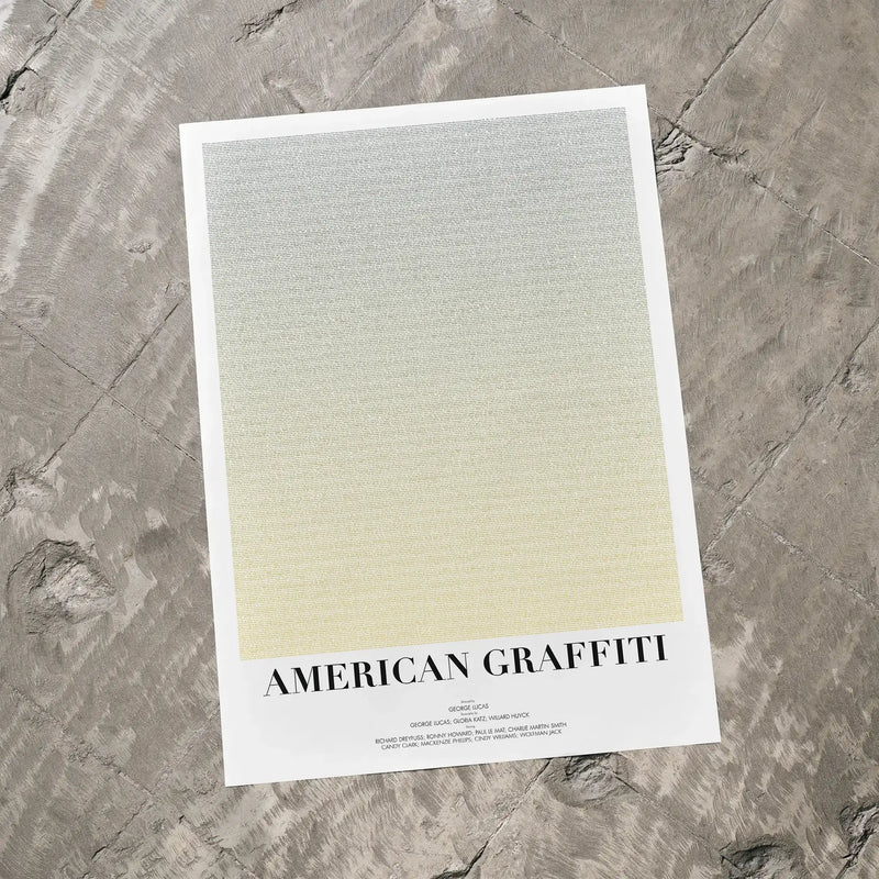 A American Graffiti movie script poster laid flat on a textured floor surface.