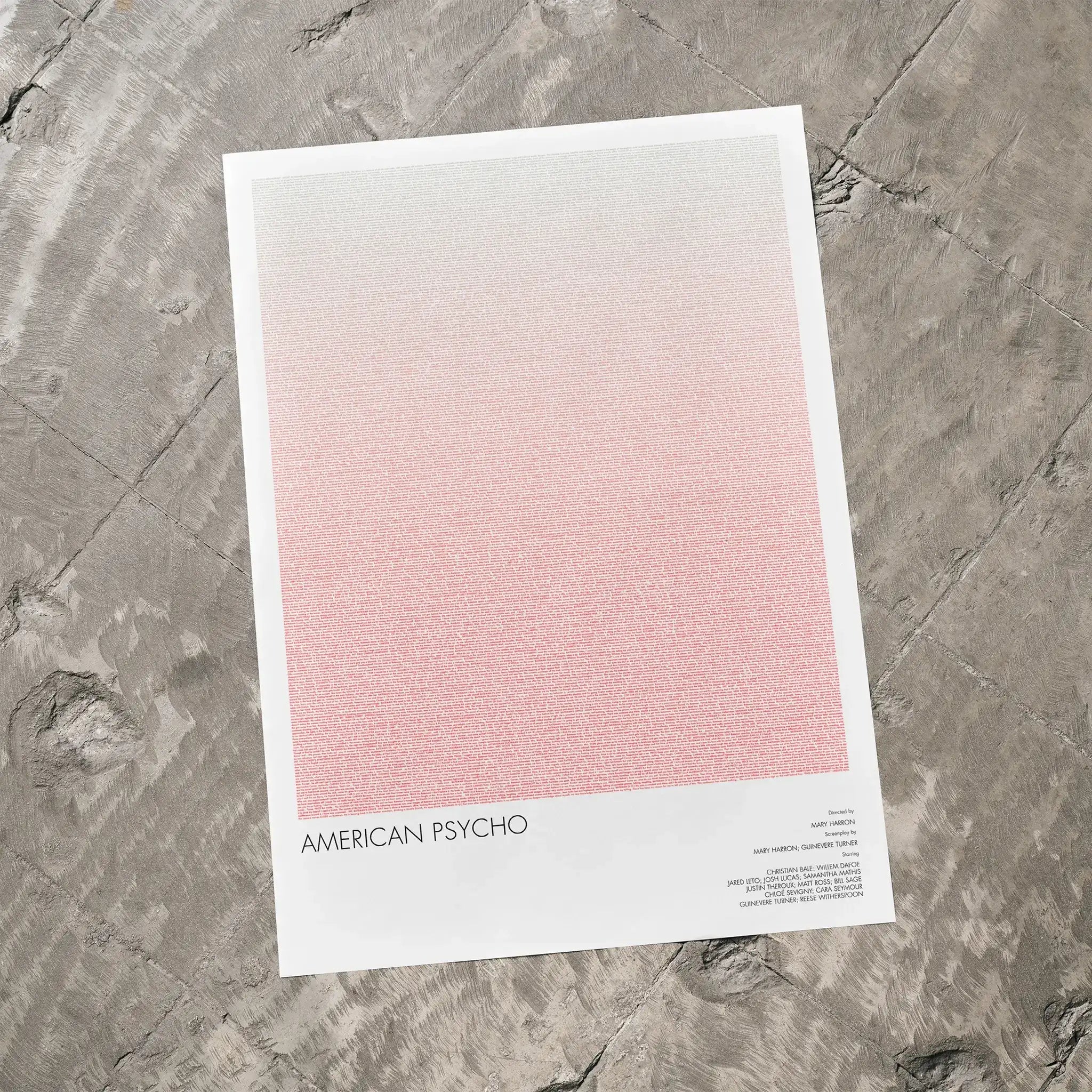 A American Psycho movie script poster laid flat on a textured floor surface.