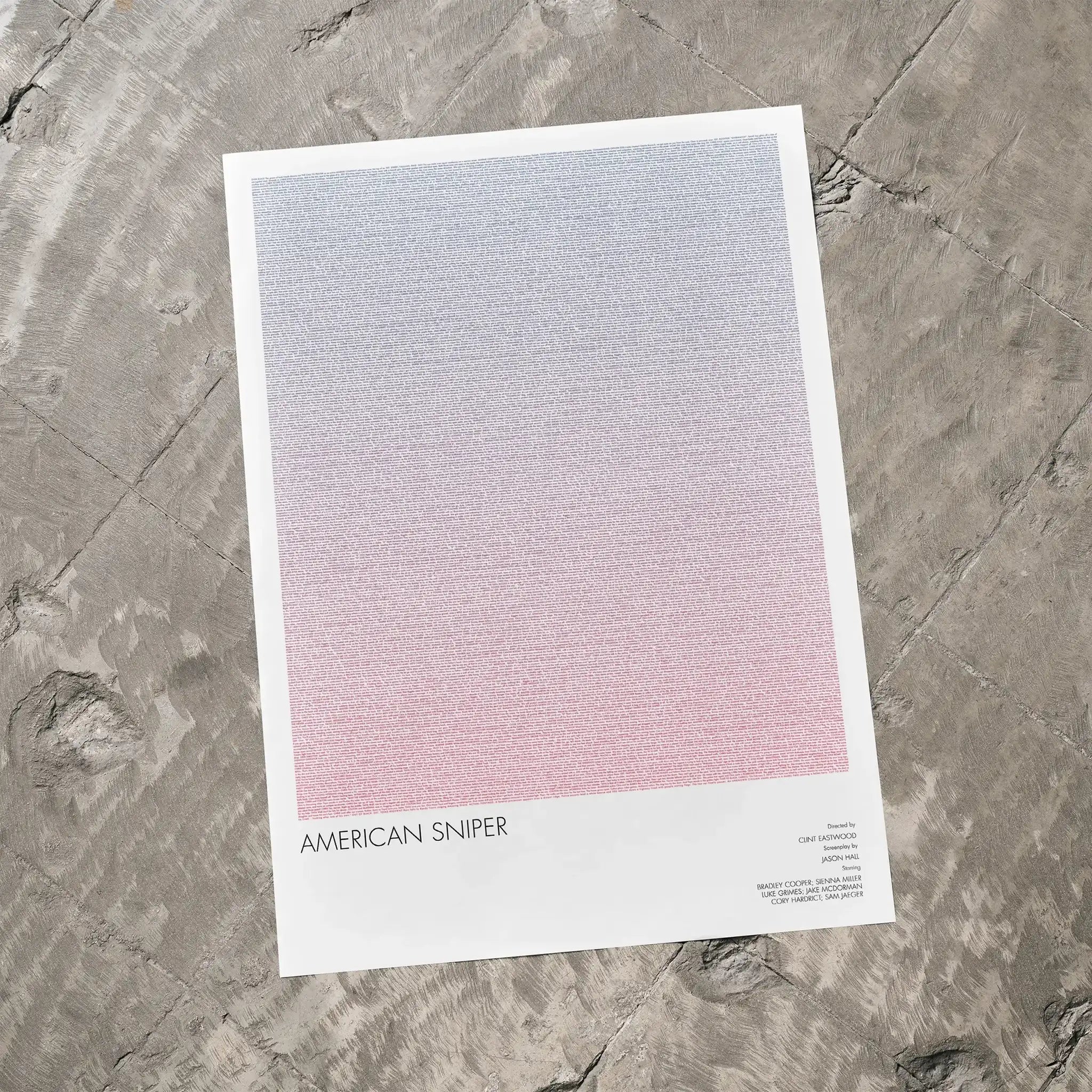 A American Sniper movie script poster laid flat on a textured floor surface.