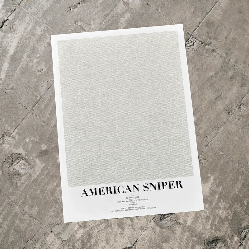 A American Sniper movie script poster laid flat on a textured floor surface.
