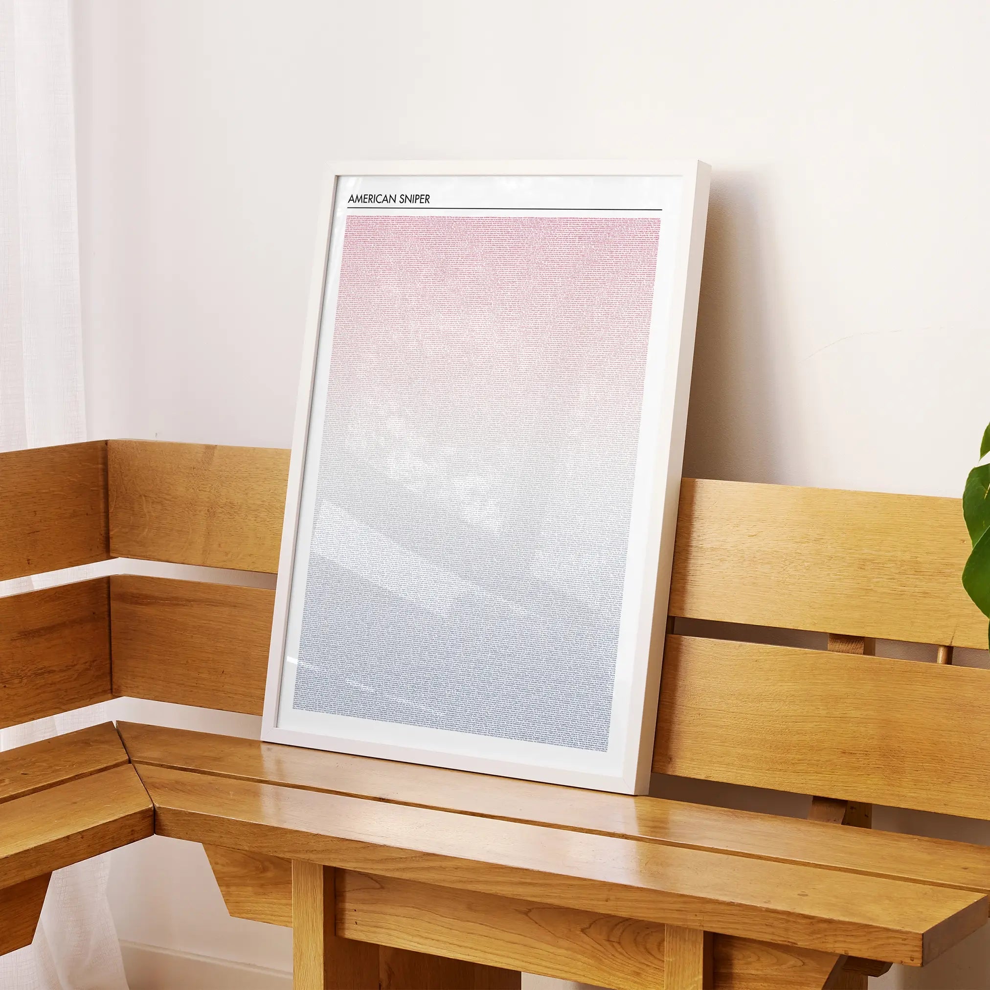 A framed American Sniper movie script poster displayed on a sideboard in a contemporary space.