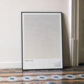 A framed Annie Hall movie script poster leaning against a wall in a minimalist interior.