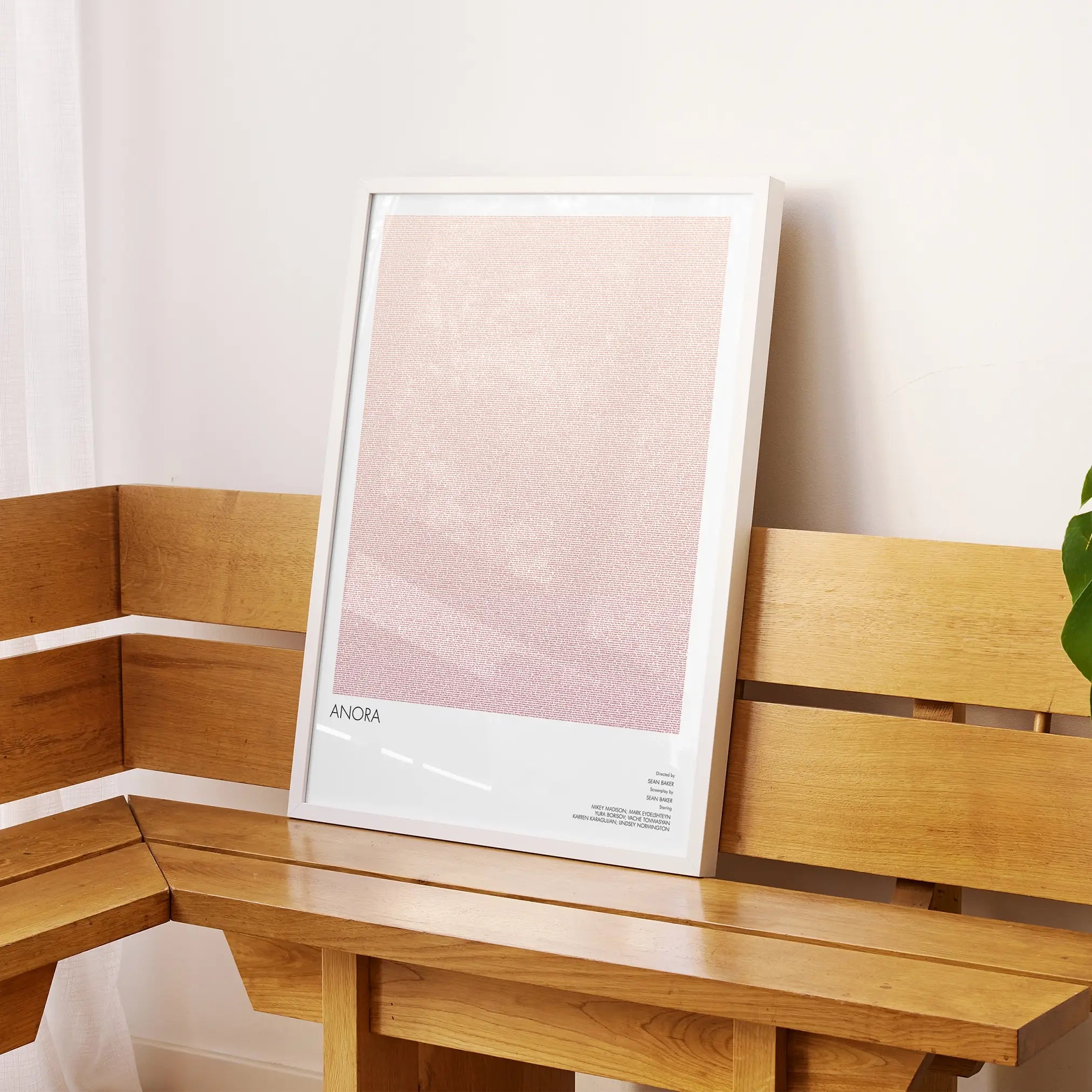 A framed Anora movie script poster displayed on a sideboard in a contemporary space.