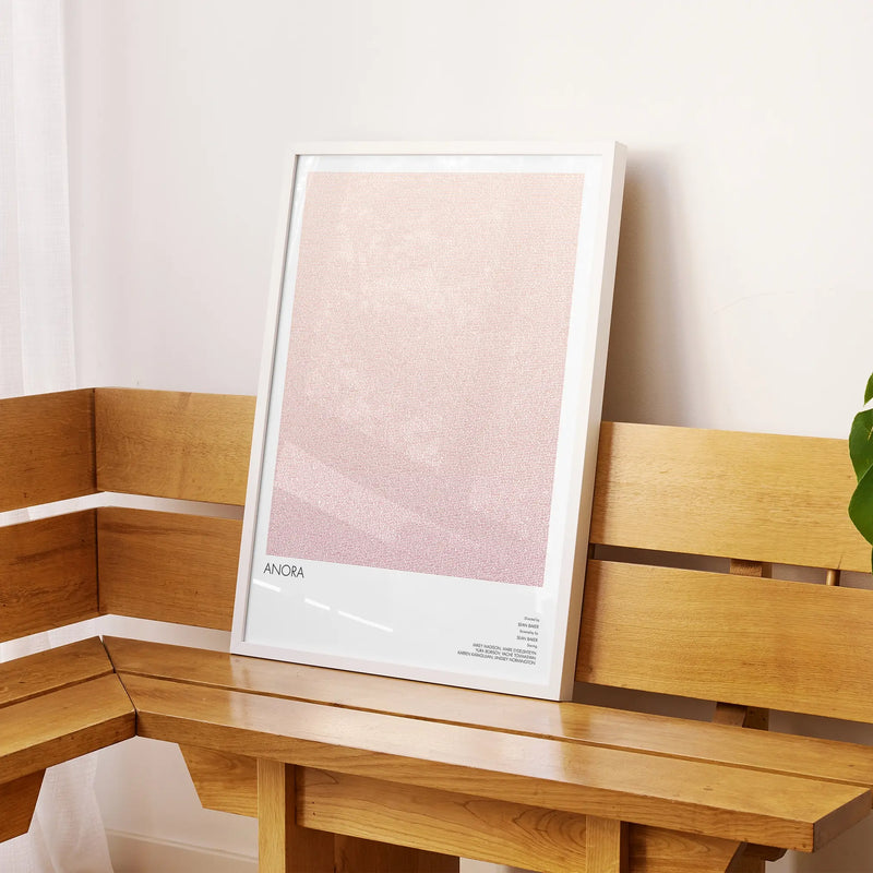 A framed Anora movie script poster displayed on a sideboard in a contemporary space.