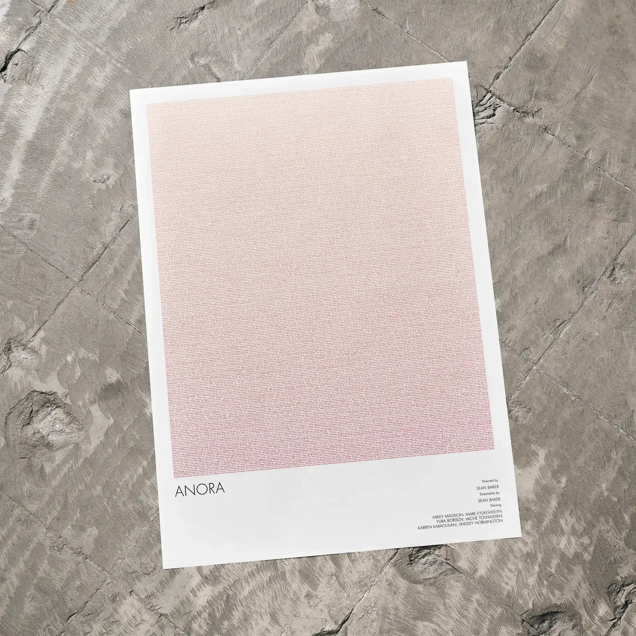 A Anora movie script poster laid flat on a textured floor surface.