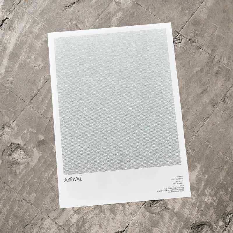 A Arrival movie script poster laid flat on a textured floor surface.