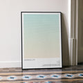 A framed Asteroid City movie script poster leaning against a wall in a minimalist interior.