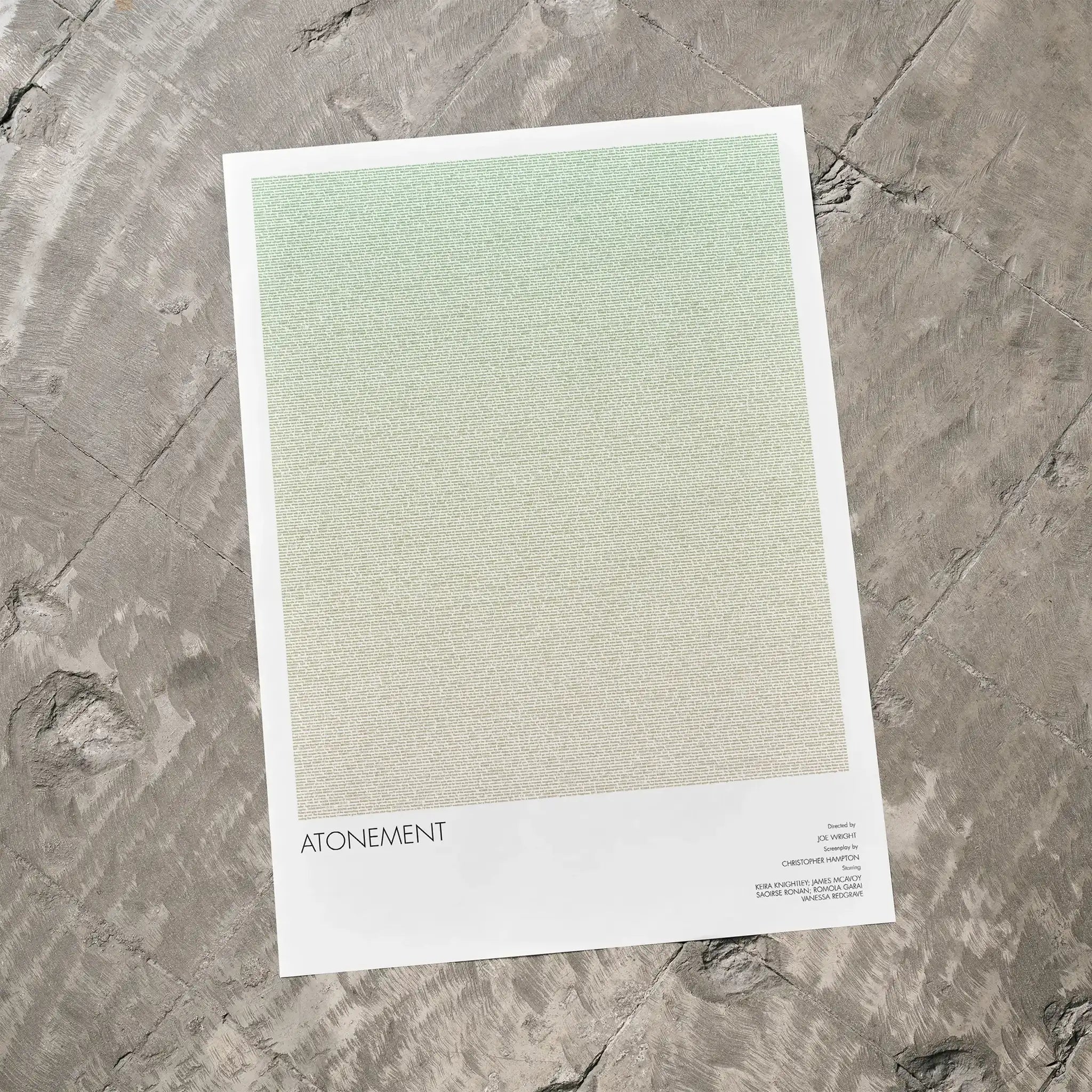 A Atonement movie script poster laid flat on a textured floor surface.