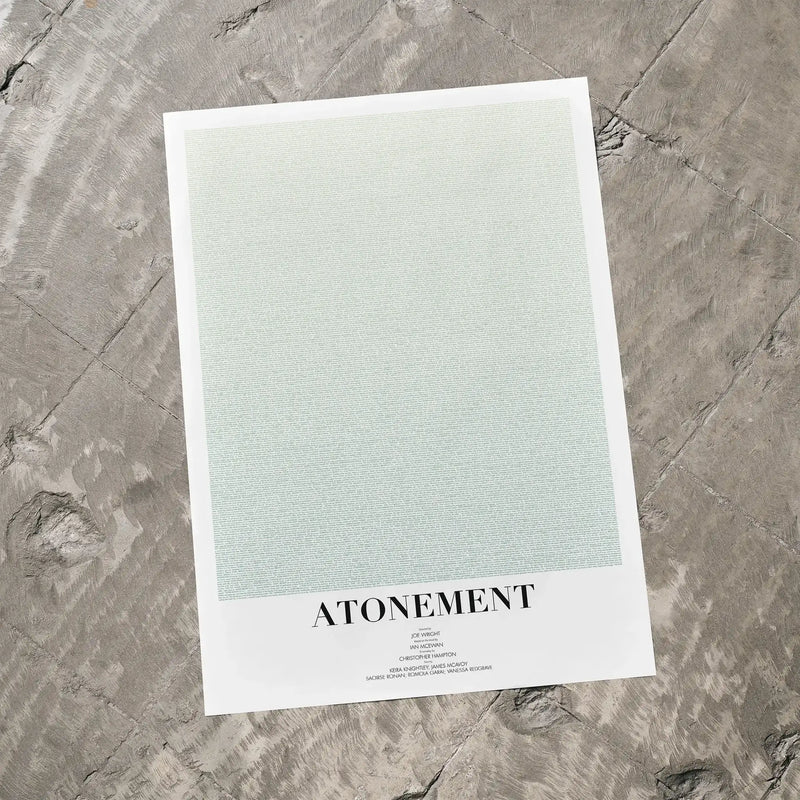 A Atonement movie script poster laid flat on a textured floor surface.
