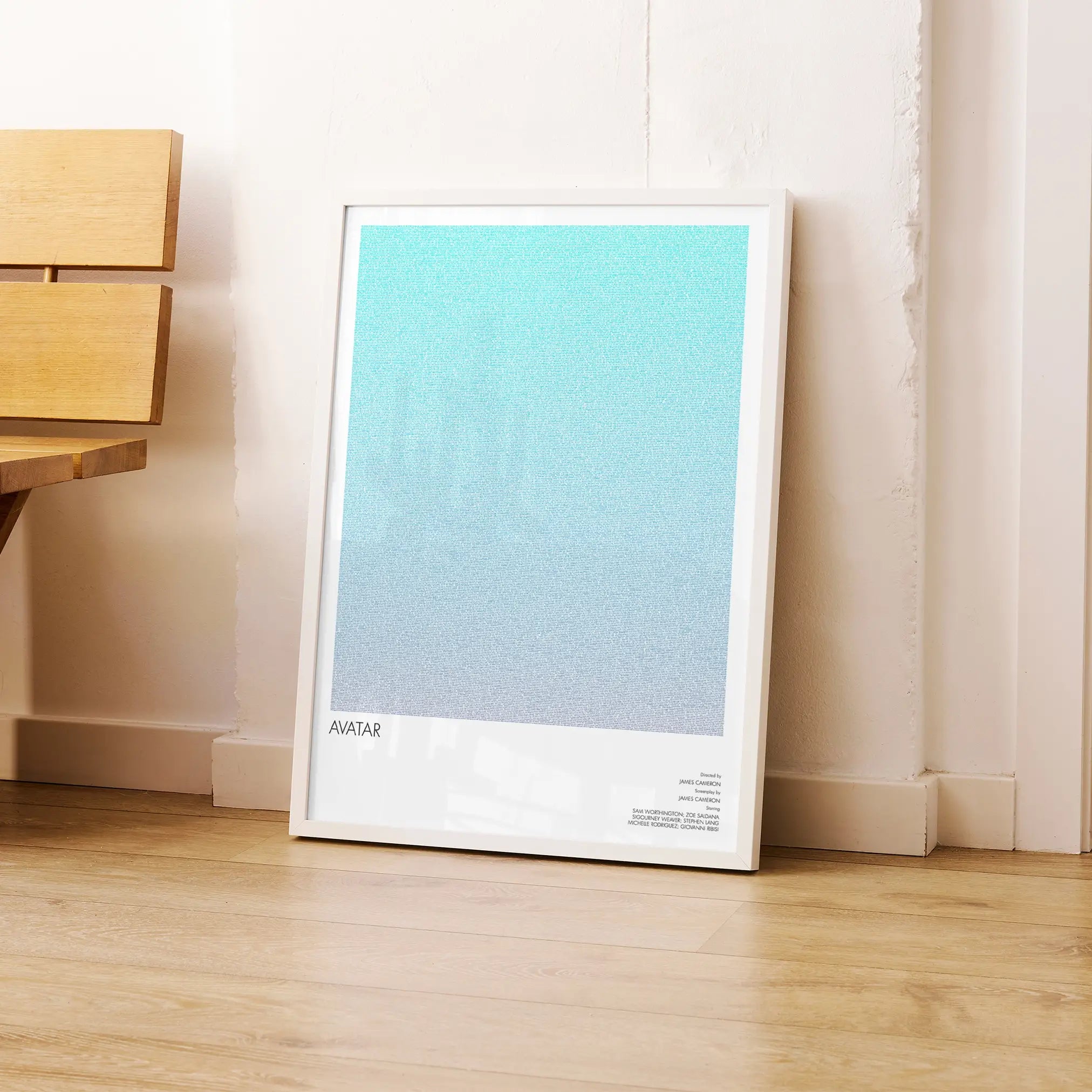 A framed Avatar movie script poster leaning against a wall in a modern interior.