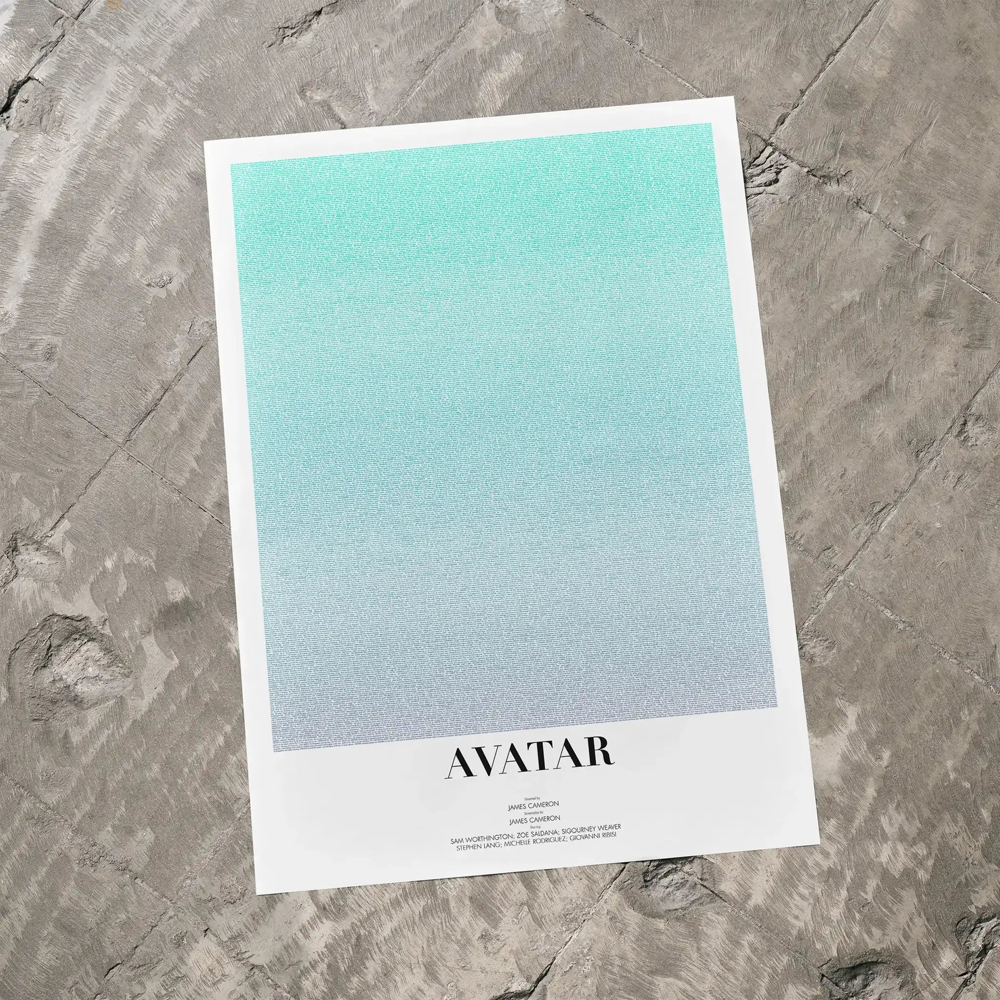 A Avatar movie script poster laid flat on a textured floor surface.