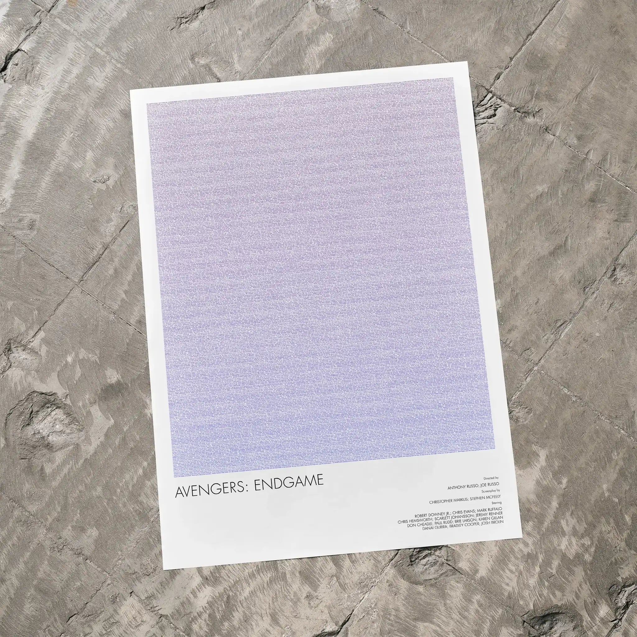 A Avengers: Endgame movie script poster laid flat on a textured floor surface.