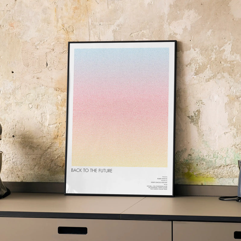 A framed Back to the Future movie script poster displayed on a cabinet in a minimalist interior.