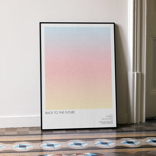 A framed Back to the Future movie script poster leaning against a wall in a minimalist interior.
