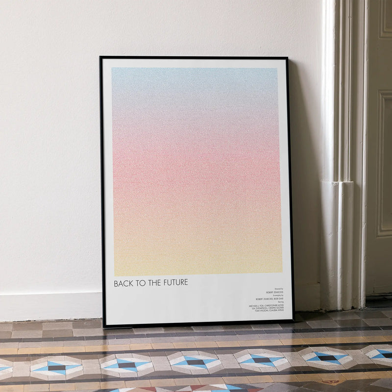 A framed Back to the Future movie script poster leaning against a wall in a minimalist interior.