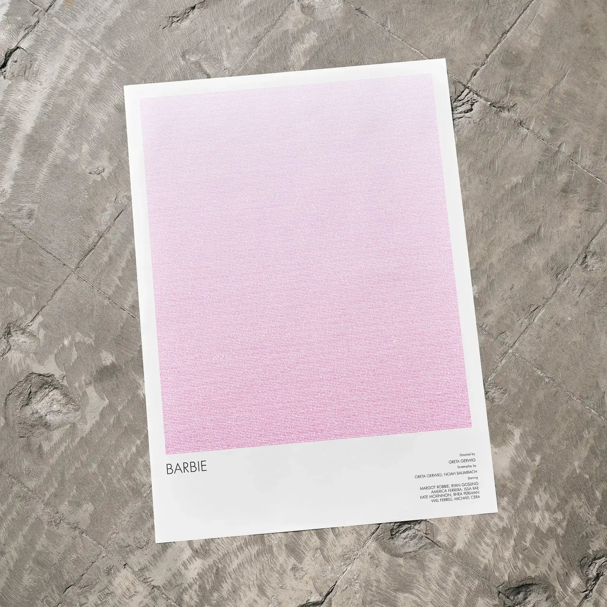 A Barbie movie script poster laid flat on a textured floor surface.