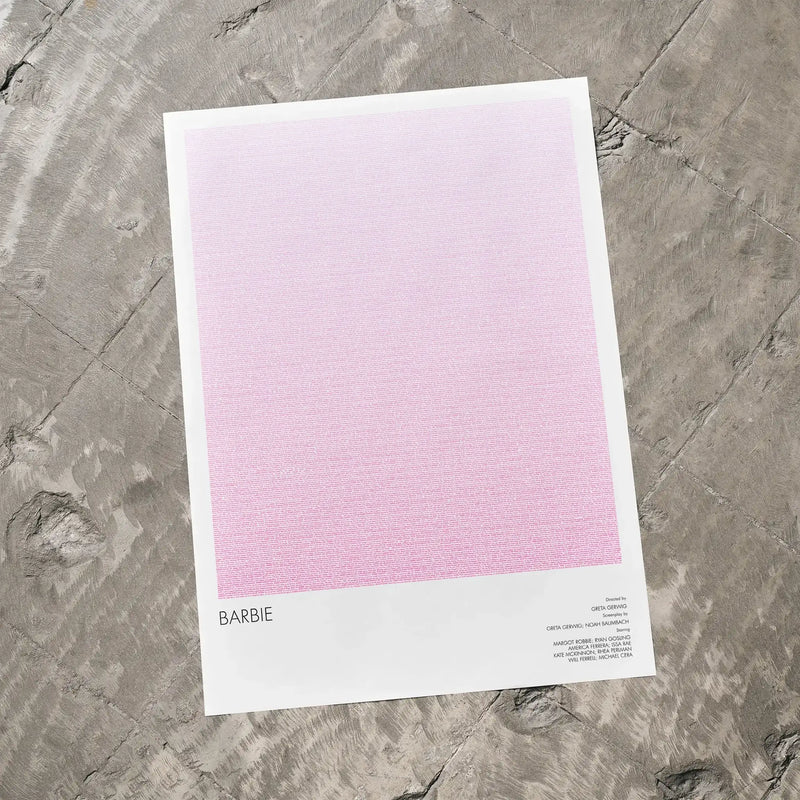 A Barbie movie script poster laid flat on a textured floor surface.