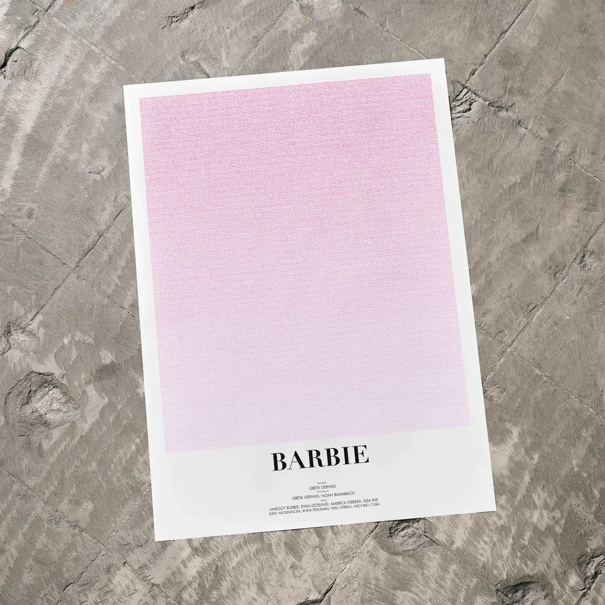 A Barbie movie script poster laid flat on a textured floor surface.