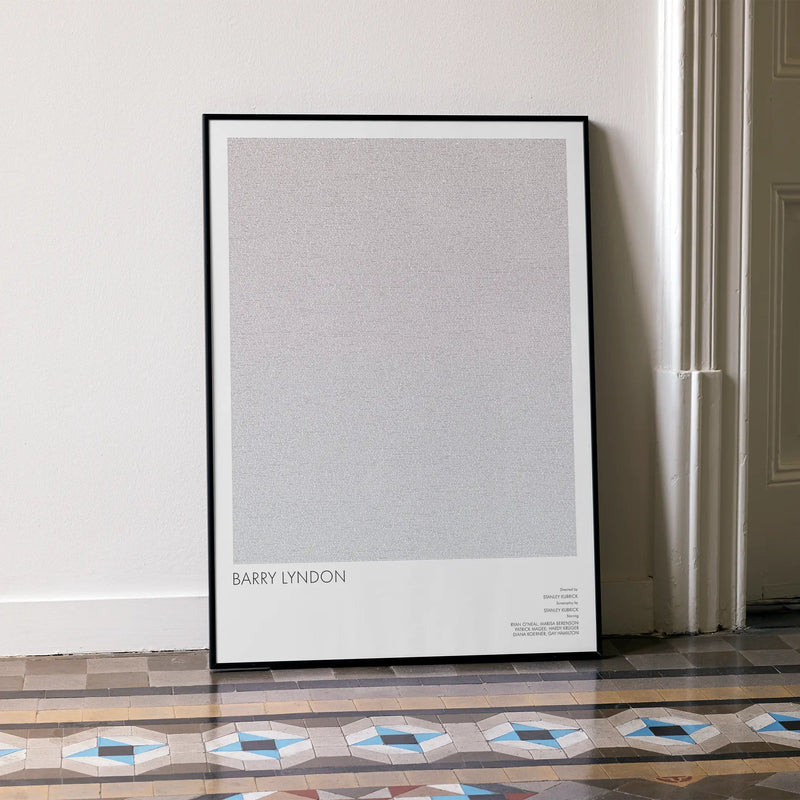 A framed Barry Lyndon movie script poster leaning against a wall in a minimalist interior.