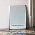 A framed Before Midnight movie script poster leaning against a wall in a minimalist interior.