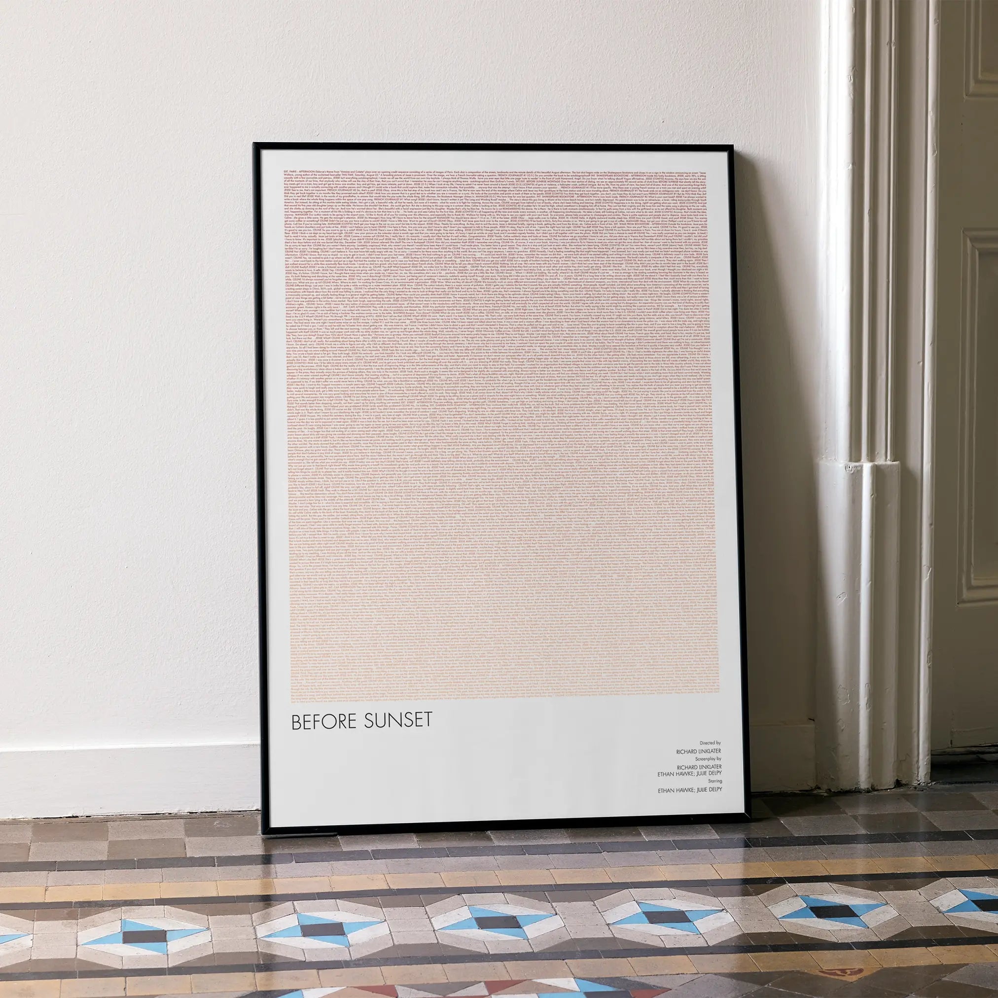 A framed Before Sunset movie script poster leaning against a wall in a minimalist interior.