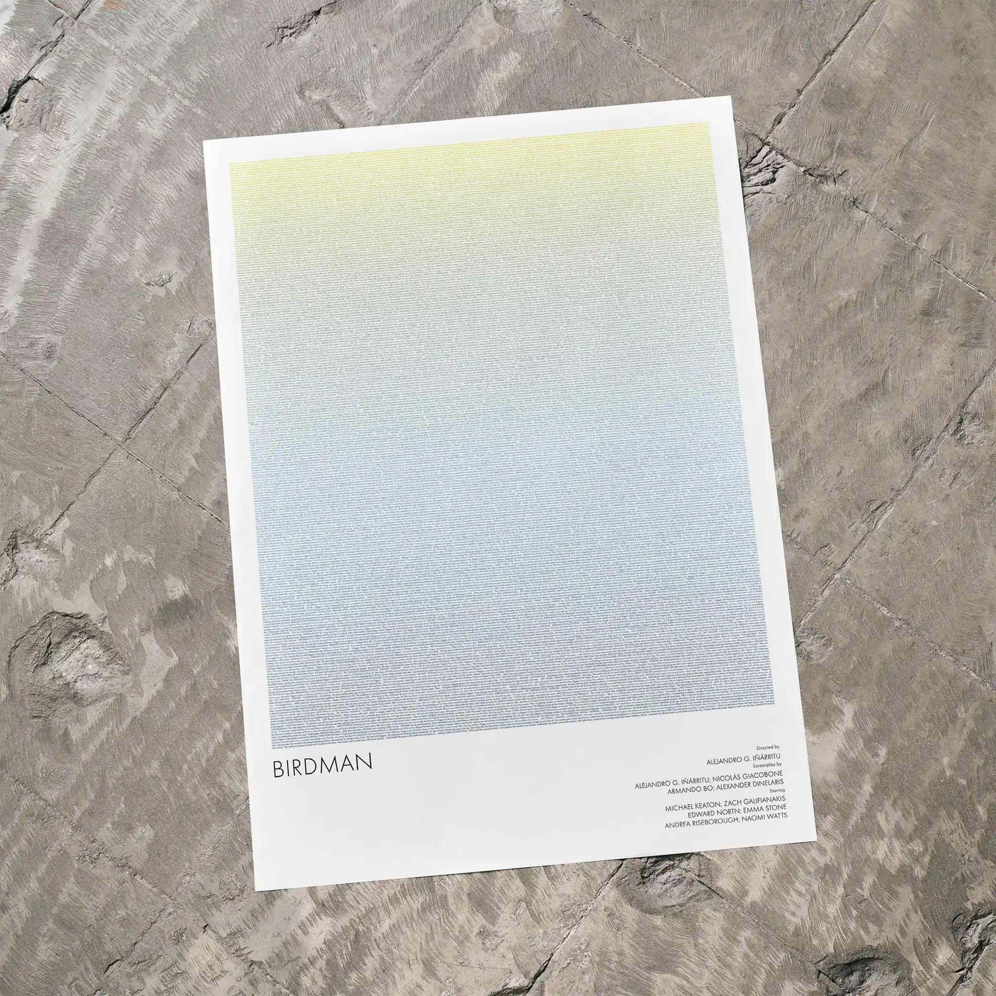 A Birdman or movie script poster laid flat on a textured floor surface.